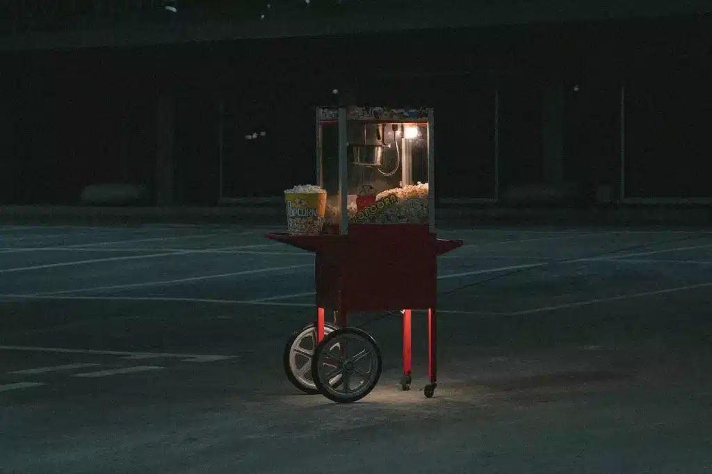 Carrinho de pipoca vermelho em um local com pouca iluminação