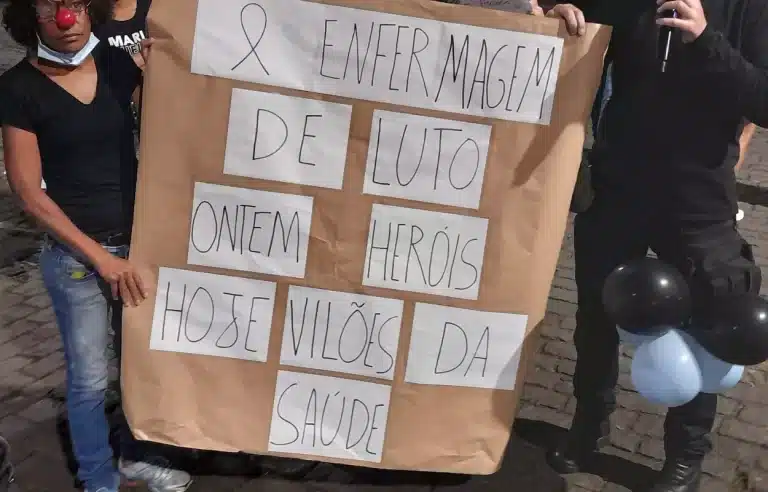 Cartaz exibido pelos manifestantes; "Enfermagem de luto. Ontem, heróis. Hoje, vilões da Saúde"